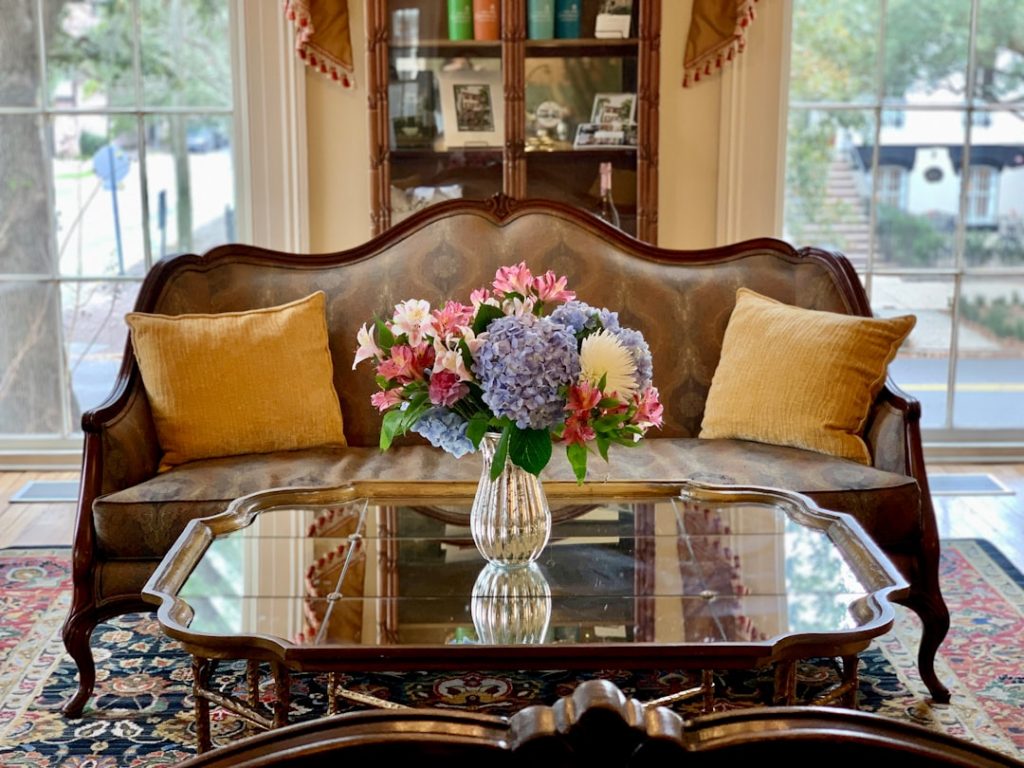 a-living-room-with-a-couch-and-a-table-with-flowers-on-it-u6asi3mta4q